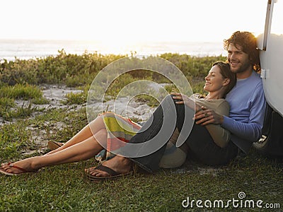 Couple On Beach Leaning On Campervan Stock Photo
