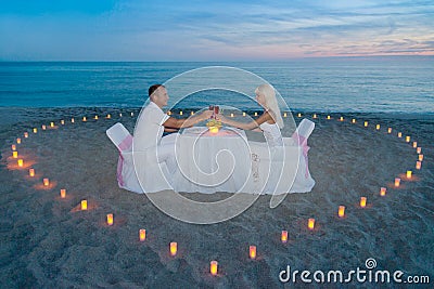 Couple at beach romantic dinner with candles heart Stock Photo