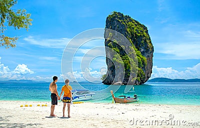 Couple on the beach, standing holding hands looking at the beautiful sea view at Poda Island - Krabi Thailand Editorial Stock Photo