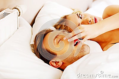 Couple in bed,man snoring woman can't sleep Stock Photo