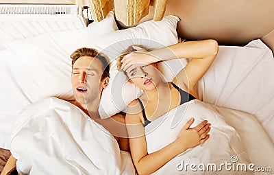 Couple in bed,man snoring woman can't sleep Stock Photo