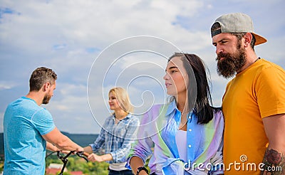 Couple with bicycle having great time while another couple bored. Couples spend leisure different way sky background Stock Photo