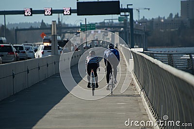 A couple of bicyclists ride from Eastside to Seattle on Evergreen Floating Bridge trail Stock Photo