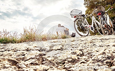 Couple on a bike trip. Lovers sitting on beach. Stock Photo