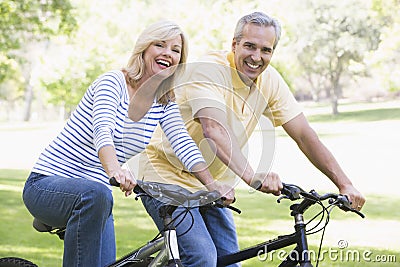 Couple on bikes outdoors smiling Stock Photo