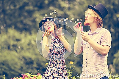 Couple blowing bubbles outdoor Stock Photo