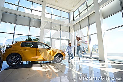 Couple of buyers rejoicing over their new automobile purchase Stock Photo