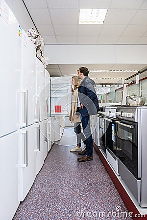 Couple Buying Refrigerator In Hypermarket Stock Photo