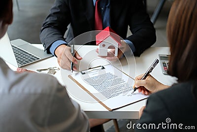 Couple buying renting house signing mortgage contract agreement with realtor real estate agent Stock Photo