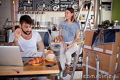 Couple cafe owner working on laptop ready to open their cafe Stock Photo