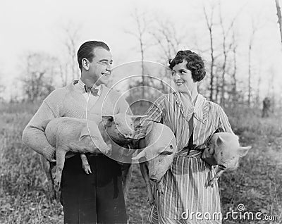 Couple carrying pigs Stock Photo