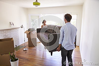 Couple Carrying Sofa Into New Home On Moving Day Stock Photo