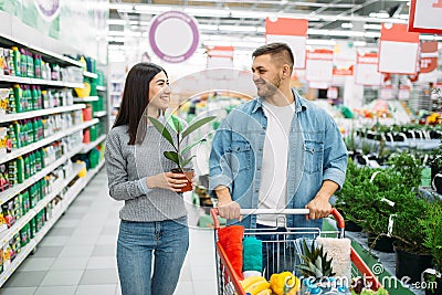 Couple with cart buying home flower in supermarket Stock Photo