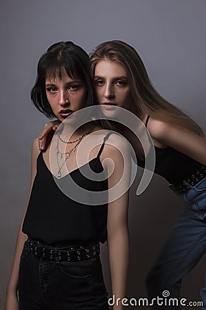 Couple of Caucasian Lesbian Girls Embracing Together Over Dark Background Stock Photo