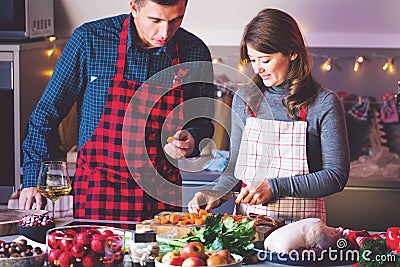 Couple celebrating Christmas in the kitchen cooking christmas duck or Goose Stock Photo