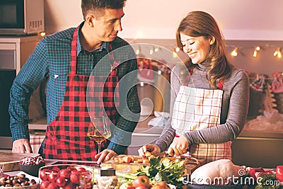 Couple celebrating Christmas in the kitchen cooking christmas duck or Goose Stock Photo