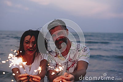 Couple celebrating with sparklers at the beach Stock Photo