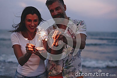 Couple celebrating with sparklers at the beach Stock Photo