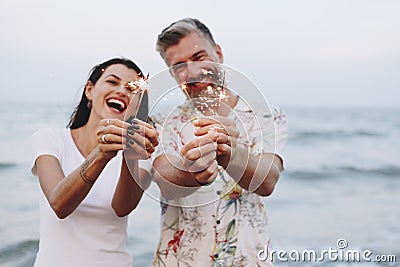 Couple celebrating with sparklers at the beach Stock Photo