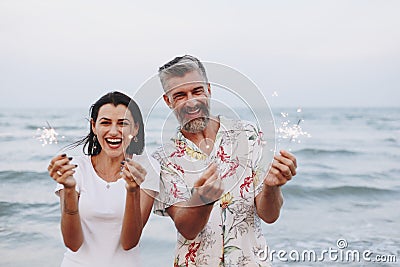 Couple celebrating with sparklers at the beach Stock Photo