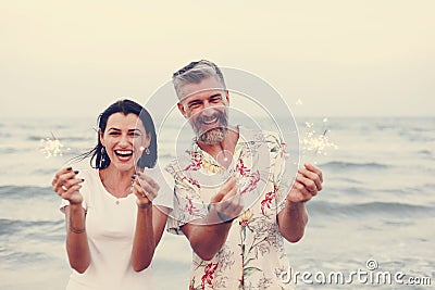 Couple celebrating with sparklers at the beach Stock Photo