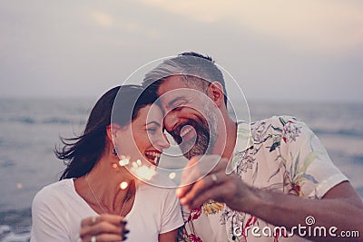 Couple celebrating with sparklers at the beach Stock Photo