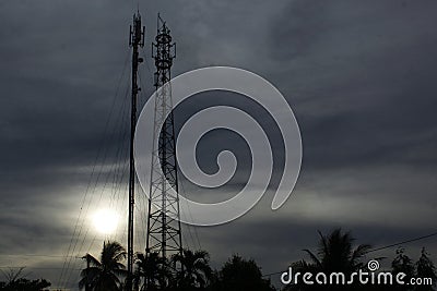 Couple Cell SiteTower in Communacation the Golden Hour gray Sunset on a land Field Stock Photo