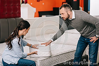 couple choosing folding mattress together in furniture store Stock Photo