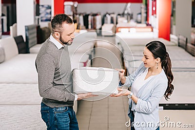 couple choosing folding mattress together in furniture store Stock Photo