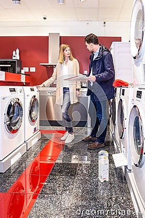 Couple Choosing Washing Machine In Hypermarket Stock Photo