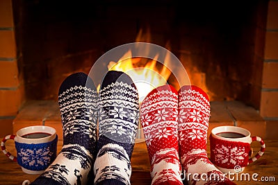 Couple in Christmas socks near fireplace Stock Photo
