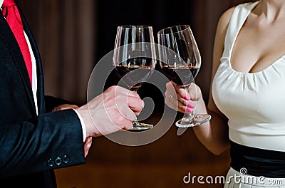 Couple clink glasses with red wine at meeting or wedding Stock Photo