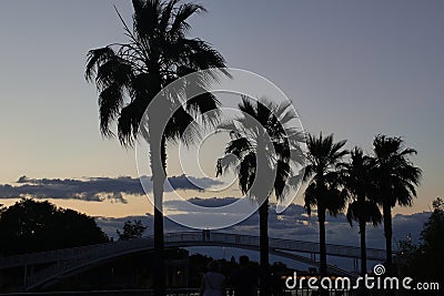 A couple contemplates the sunset in a landscape with clouds Stock Photo