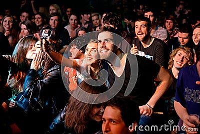 A couple from the crowd takes a selfie with a Gopro camera at Bikini stage Editorial Stock Photo