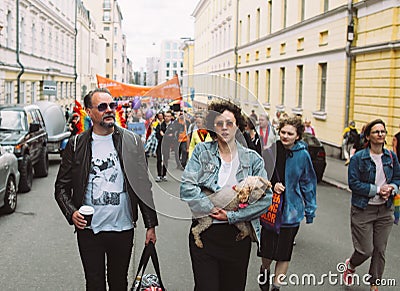 Couple with dog on hands on Helsinki Pride festival on the street Editorial Stock Photo