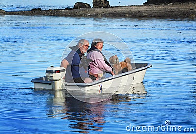 Couple with dog on small boat Stock Photo