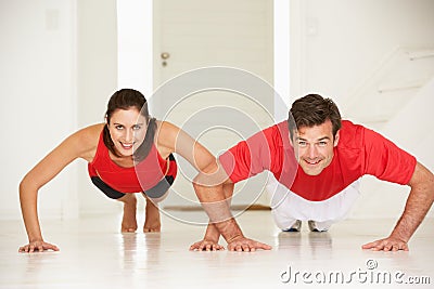 Couple doing push-ups in home gym Stock Photo