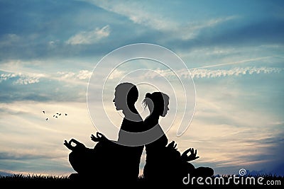 Couple doing yoga at sunset Stock Photo