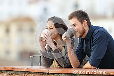 Couple drinking coffee contemplating views Stock Photo