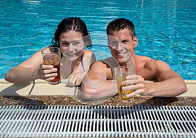 Couple with drinks in the sund at pool Stock Photo