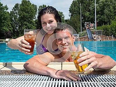 Couple with drinks in the sund at pool Stock Photo