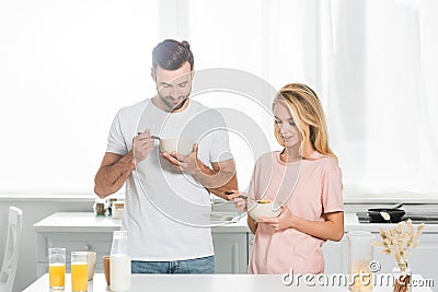 Couple eating cereal during breakfast at kitchen Stock Photo