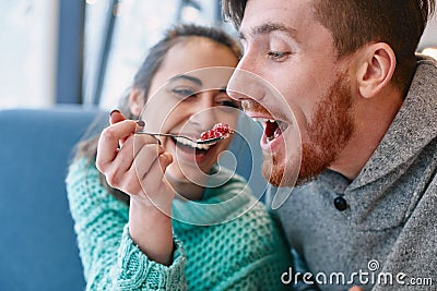 Couple eating a dessert spoon in cafe on date Stock Photo