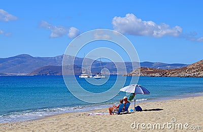 Couple enjoying beach holiday on the coast of Naxos island in Greece. Editorial Stock Photo