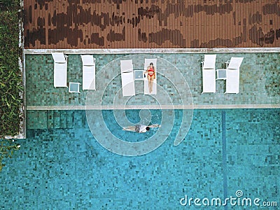 A couple enjoying a beach vacation at a tropical resort with a beautifully landscaped coastal pool at sunset. honeymoon Stock Photo