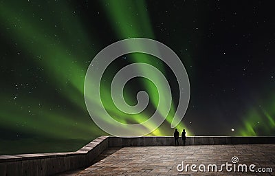 Couple enjoying beautiful Aurora Borealis at night Stock Photo