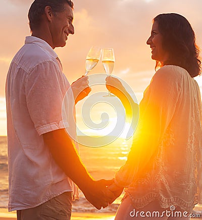 Couple Enjoying Glass of Champene on the Beach at Sunset Stock Photo