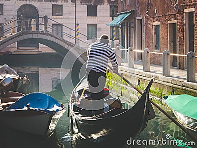 Couple enjoying gondola tour in the water channel of Venice Editorial Stock Photo