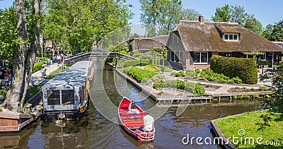 Couple enjoying the histori architecture in a red boat in Giethoorn Editorial Stock Photo