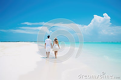 A couple enjoying a romantic stroll on the beach, holding hands and taking in the beautiful surroundings, young couple walking on Stock Photo